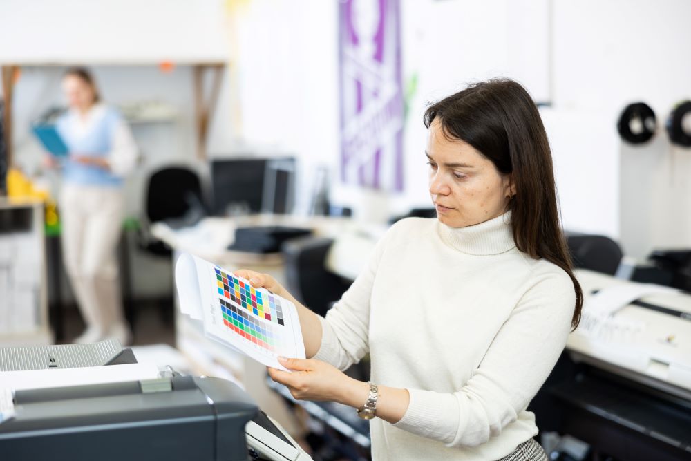 An office worker reviewing print outputs signifying Managed Print Services