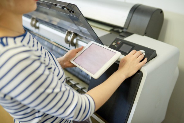 faceless woman setting printer with tablet picture id981930424 - Copiers & Printers
